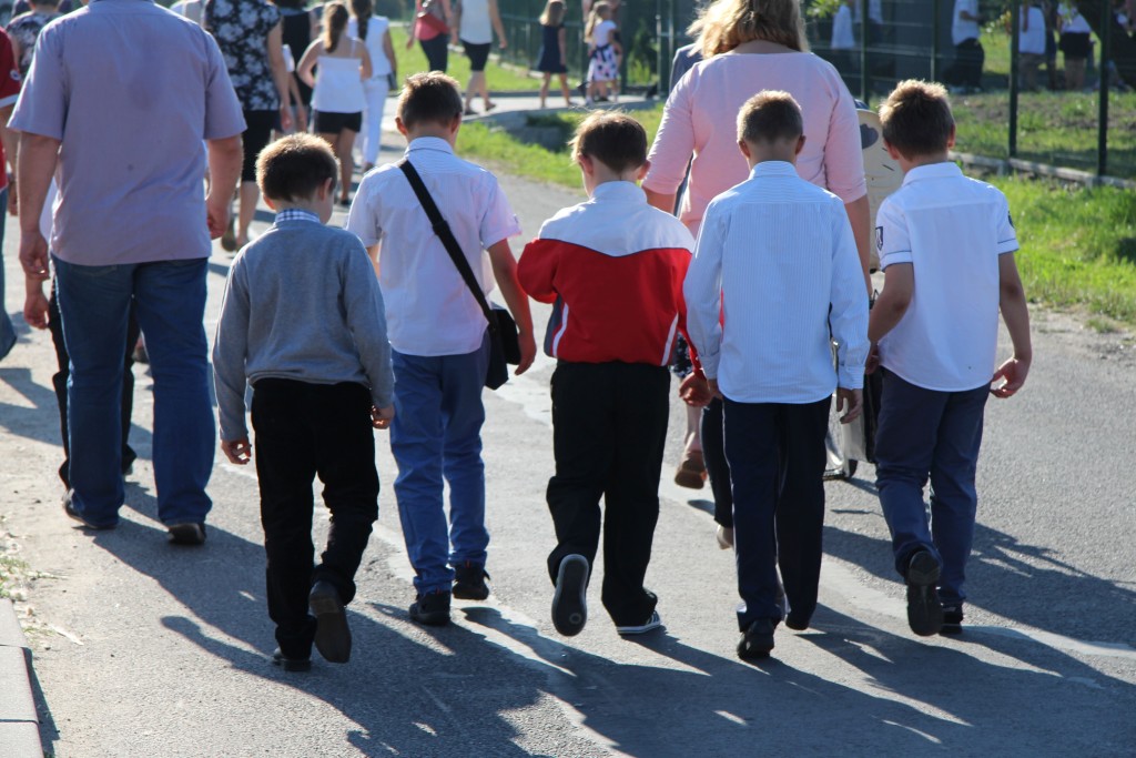 dzieci tyłem idące do szkoły