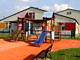 Przedszkole w Bujnach kolorowe zjeżdżalnie na tle budynków przedszkola