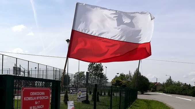 flaga przy tabliczce lokalu wyborczego