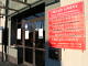 Wejście do budynku Urzędu Gminy. Na pierwszym planie czerwone tablice informacyjne