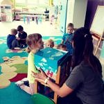 Dzieci podczas zabawy na kolorowym dywanie podczas zajęć w przedszkolu