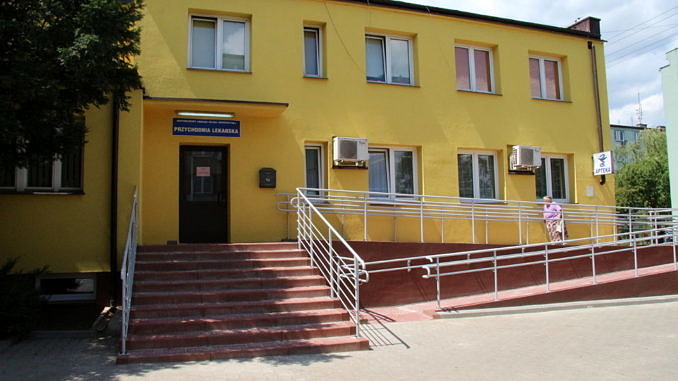 Óśrodek zdrowia w Woli Krzysztoporskiej - żółty budynek ze schodami i podjazdem dla niepełnosprawnych