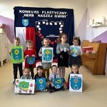 Grupa przedszkolaków prezentuje wykonane własnoręcznie herby gminy Wola Krzysztoporska