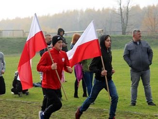 Biegacze z biało-czerwonymi flagami