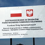 Tablica informacyjna o dofinansowaniu przebudowy drogi Rokszyce - Oprzężów ze środków Panstwowego Funduszu Celowego - Funduszu Dróg Samorządowych