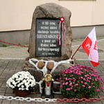 Ponik "100. rocznice śmierci Tadeusza Kościuszki" w Woli Krzysztoprskiej udekorowany kwiatami, biało-czerwoną flagą i kotylionem