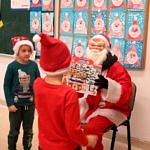 Mikołaj wręcza prezent dzieciom