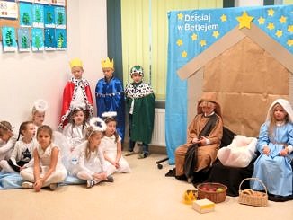 Dzieci podczas występów jasełkoych - dziewczynki w białych suienkach przebrane za aniołki, chłopcy za pasterzy, Trzej Królowie i Święta Rodzina