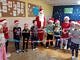 Grupa dzieci z Mikołajem - trzymają kolorowy łańcuch z papieru