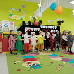 Dzieci w kolorowych strojach podczas inscenizacji z okazji Dnia Babci