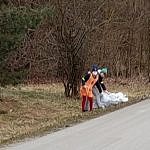 Osoby z workami sprzątające śmieci