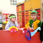 Dzieci pdczas zabaw przy stole; Dzieci z wykonanymi własnoręcznie dinozaurami