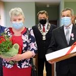 starsi ludzie - para małżeńska - odbierają od przedstawicieli gminy madal za długoletnie pożycie małżeńskie; ootrzymują też kwiaty i prezent od przedstawicieli gminy