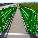 Nowa kładka nad autostradą z robudowanym podkazdem dla niepełnosprawnych w kolorach żółtym i zielonym
