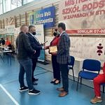 Organizator Tomasz Woźniak wręcza podziękowania przedstawicielom szkoły i gminy