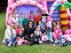 Grupa dzieci z opiekunami sziedzi na różowej dmuchanej zjeżdżalni