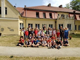 Grupa dzieci z nauczycielami przed szkołąw Parznirwicach