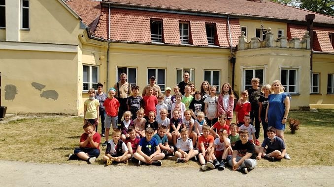Grupa dzieci z nauczycielami przed szkołąw Parznirwicach
