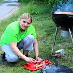 Kobieta przygotowuje kiełbaski na grill