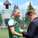Kapitan LZS OSP Gomulin w zielonej koszulce odbiera puchar z rak wójta gminy Romana Drozdka