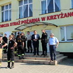 Strażacy, wójt Roman Drozdek i przedstawiciele PSP stoją przed budynkiem OSP w Krzyżanowie