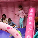 Dzieci na dmuchanej różowej zjeżdżalni