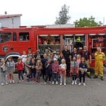 Zdjęcie zbiorowe dzieci i strażaków przed wozem strażackim