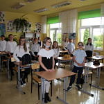Dzieci stoją przy ławkach w klasie