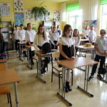Dzieci stoją przy ławkach w klasie