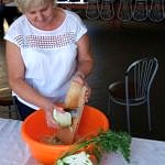 Kobieta szatkuje kapustę do pomarańczowej miski