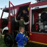 Dzieci wsiadaja do samochodu strażackiego