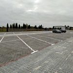 Gotowy parking z kostki betonowej i płyt ażurowych z zaznaczonymi miejscami parkingowymi i znakami poziomymi