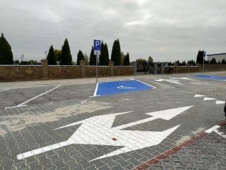 Gotowy parking z kostki betonowej i płyt ażurowych z zaznaczonymi miejscami parkingowymi i znakami poziomymi