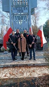 Grupa ludzi z bialo-czerwonymi flagami przed Pomnikiem Obrońców Gór Borowskich