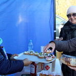 Panie z KGW Bujny pod niebieskim namiotem oferują ciasta na aukcję