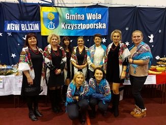 Zdjęcie zbiorowe KGW Blizinni Kamienna na tle baneru Gmina Wola Krzysztoporska