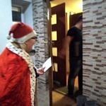 Osoba w przebraniu św. Mikołaja zbliża się do drzwi