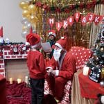 Dzieci w mikołajkowych czapkach i czerwonych strojach z Mikołajem