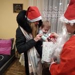 Mikołaj wręcza prezent malutkiemu dziecku
