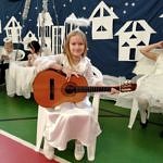 Dziewczynka w białej sukience z gitarą