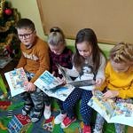 Przedszkolaki czytają książki siedząc na kolorowych piankowych kanapach