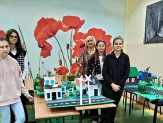 Autorki projektu - zielono niebieskiej ekologicznej makiety stoją z opiekunką przy swoim dziele