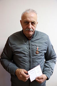 Ryszard Cieślak z legitymcją i medalem