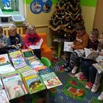 Przedszkolaki czytają książki siedząc na kolorowych piankowych kanapach