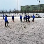 zawodnicy trenują na zaśnieżonym boisku