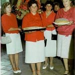 grupa konbiet z bochnami chleba w dłoniach