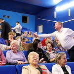 Publiczność (głównie kobiety) w sali koncertowej GOK - panowie częstują słodyczami