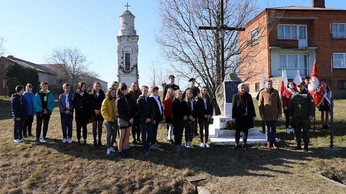 Młodzież szkoły podstawowej w bujnach przed obeliskiem pamięci pomordowanych