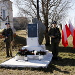 Warta dwóch młodych luydzi w mundurach przy pomniku