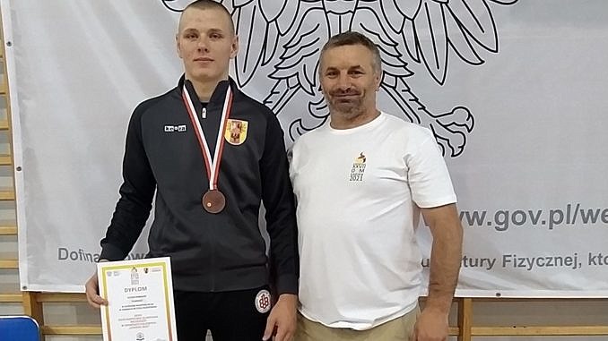 Patryk Robaszek z medalem obok jego trener Tomasz Woźniak